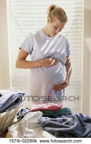 Pregnant woman touching her abdomen View Large Photo Image Stock Image - Pregnant woman touching her abdomen. Fotosearch