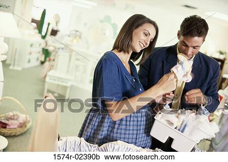 Stock Image - Pregnant woman with her husband in a shopping mall. Fotosearch
