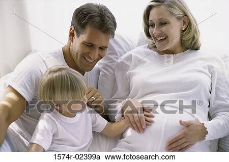 Son touching his pregnant mother's abdomen View Large Photo Image Stock Image - Son touching his pregnant mother's abdomen. Fotosearch