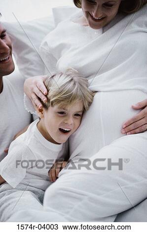Son with his head against his pregnant mother's abdomen View Large Photo Image Stock Image - Son with his head against his pregnant mother's abdomen. Fotosearch