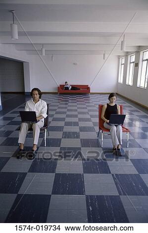 Picture - Businesswoman and a businessman using laptops. Fotosearch