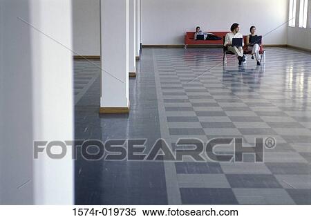 Stock Photography - Businesswoman and a businessman using laptops. Fotosearch