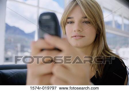Stock Photo - Close-up of a teenage girl operating a mobile phone. Fotosearch