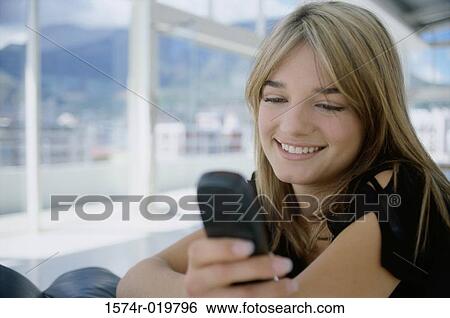 Close-up of a teenage girl operating a mobile phone View Large Photo Image Stock Photograph - Close-up of a teenage girl operating a mobile phone. Fotosearch