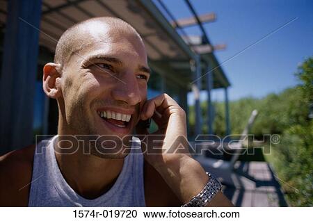 Stock Image - Close-up of a young man talking on a mobile phone. Fotosearch