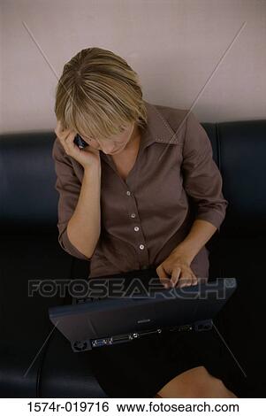 High angle view of a businesswoman using a mobile phone and a laptop View Large Photo Image Stock Photograph - High angle view of a businesswoman using a mobile phone and a laptop. Fotosearch