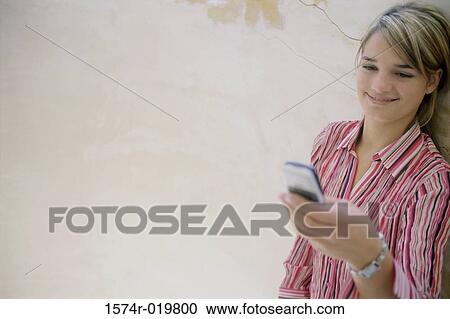 High angle view of a teenage girl operating a mobile phone View Large Photo Image Stock Image - High angle view of a teenage girl operating a mobile phone. Fotosearch