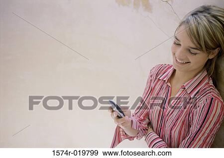 High angle view of a teenage girl operating a mobile phone View Large Photo Image Stock Photo - High angle view of a teenage girl operating a mobile phone. Fotosearch