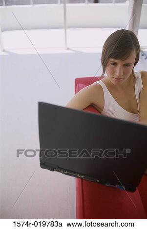 High angle view of a young woman using a laptop View Large Photo Image Stock Image - High angle view of a young woman using a laptop. Fotosearch