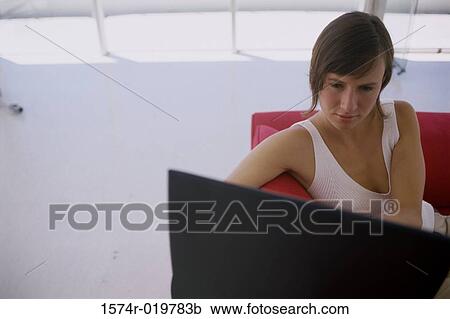 High angle view of a young woman using a laptop View Large Photo Image Stock Image - High angle view of a young woman using a laptop. Fotosearch