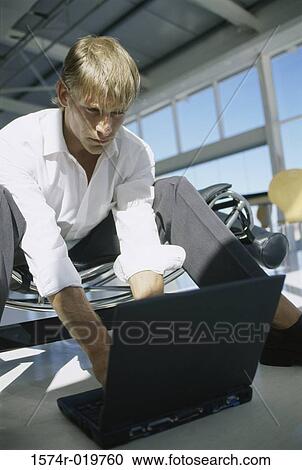 Low angle view of a businessman using a laptop View Large Photo Image Stock Image - Low angle view of a businessman using a laptop. Fotosearch