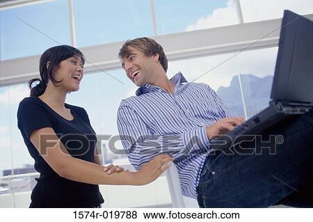 Low angle view of a businesswoman and a businessman smiling View Large Photo Image Stock Photo - Low angle view of a businesswoman and a businessman smiling. Fotosearch