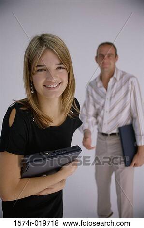Portrait of a businesswoman and a businessman holding laptops View Large Photo Image Stock Photo - Portrait of a businesswoman and a businessman holding laptops. Fotosearch