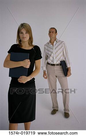 Stock Photo - Portrait of a businesswoman and a businessman holding laptops. Fotosearch