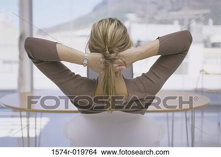 Picture - Rear view of a young woman sitting in front of a laptop. Fotosearch
