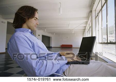 Side profile of a businessman using a laptop View Large Photo Image Stock Image - Side profile of a businessman using a laptop. Fotosearch