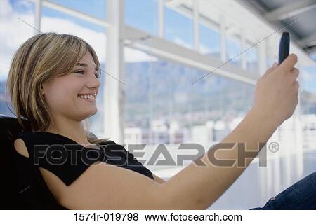 Side profile of a teenage girl operating a mobile phone View Large Photo Image Stock Photo - Side profile of a teenage girl operating a mobile phone. Fotosearch