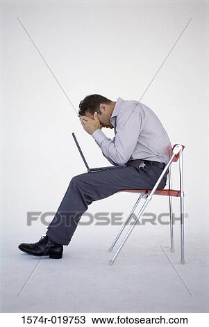 Side profile of a young man sitting in chair with a laptop on his lap View Large Photo Image Stock Image - Side profile of a young man sitting in chair with a laptop on his lap. Fotosearch