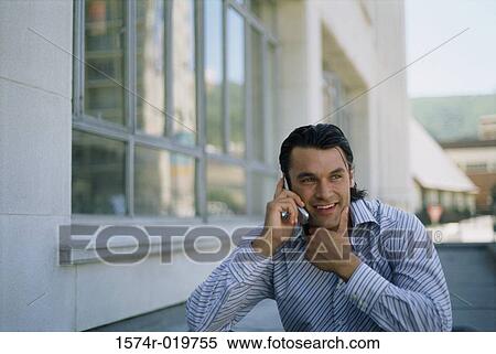 Young man talking on a mobile phone View Large Photo Image Stock Photography - Young man talking on a mobile phone. Fotosearch