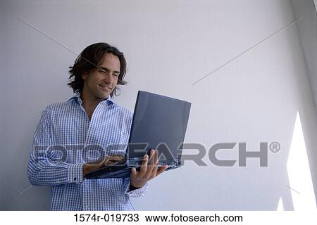 Stock Image - Young man using a laptop. Fotosearch