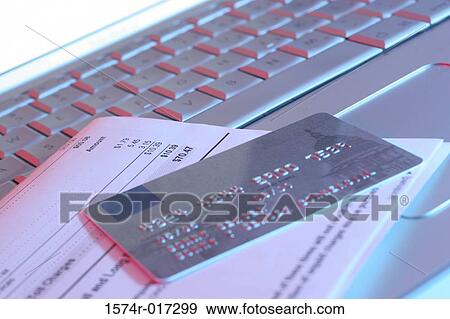 Stock Photo - Close-up of a credit card with a bill on a laptop. Fotosearch