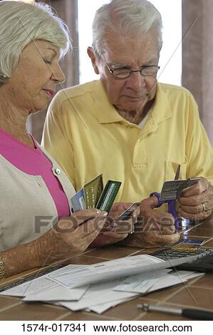 Close-up of a senior couple destroying credit cards View Large Photo Image Stock Image - Close-up of a senior couple destroying credit cards. Fotosearch
