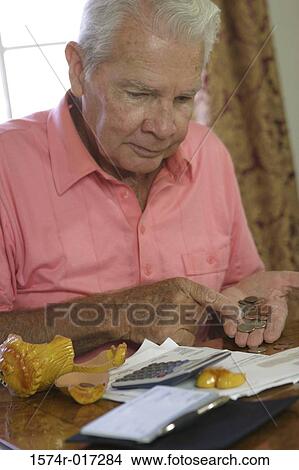 Close-up of a senior man counting coins View Large Photo Image Picture - Close-up of a senior man counting coins. Fotosearch