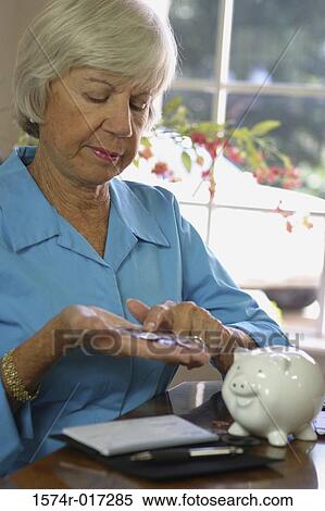 Stock Photography - Close-up of a senior woman counting coins. Fotosearch