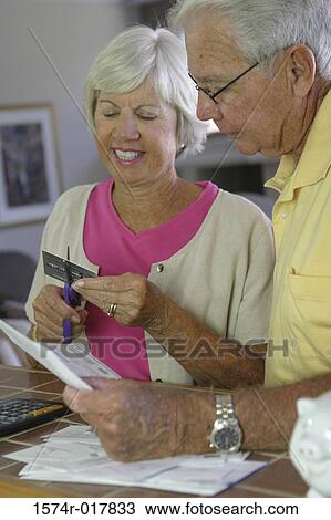 Close-up of a senior woman cutting a credit card with a pair of scissors View Large Photo Image Stock Image - Close-up of a senior woman cutting a credit card with a pair of scissors. Fotosearch