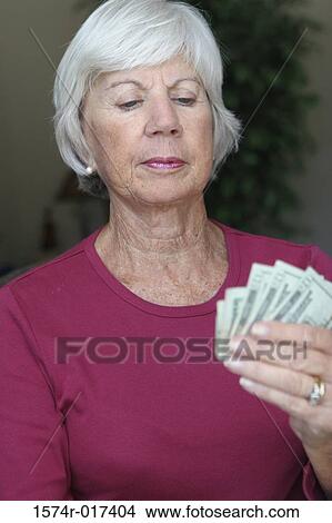 Close-up of a senior woman holding money View Large Photo Image Picture - Close-up of a senior woman holding money. Fotosearch