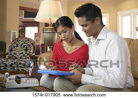 Stock Photography - Close-up of a young couple looking at a file. Fotosearch
