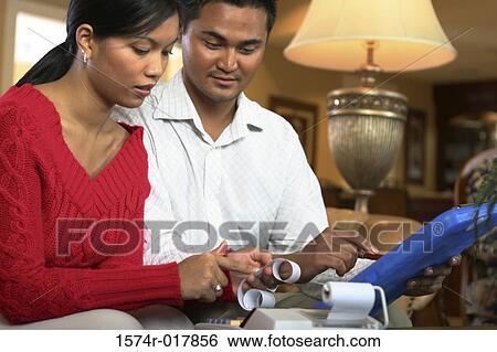 Close-up of a young couple reading a receipt View Large Photo Image Stock Photograph - Close-up of a young couple reading a receipt. Fotosearch