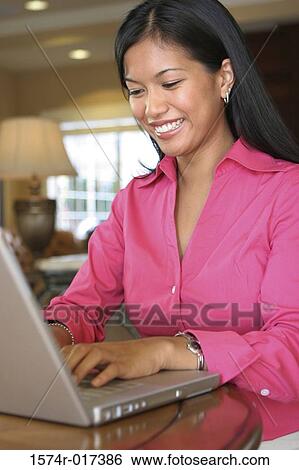 Close-up of a young woman using a laptop View Large Photo Image Stock Photograph - Close-up of a young woman using a laptop. Fotosearch
