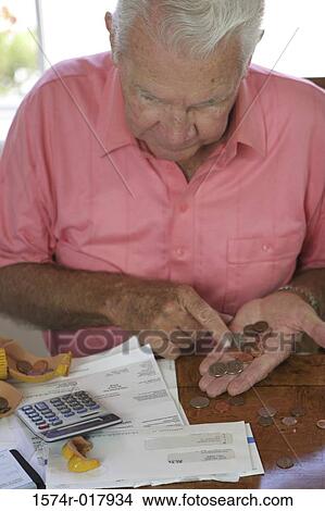 High angle view of a senior man counting coins View Large Photo Image Picture - High angle view of a senior man counting coins. Fotosearch