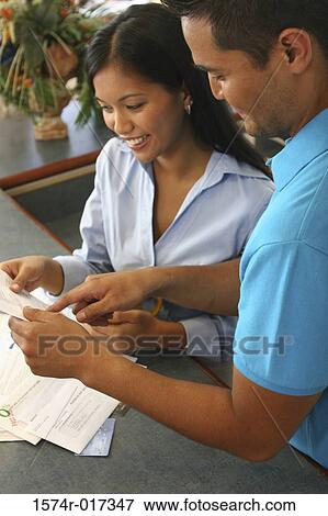 High angle view of a young couple reading a bill View Large Photo Image Stock Photo - High angle view of a young couple reading a bill. Fotosearch