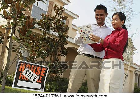 Low angle view of a young couple choosing color from a color swatch View Large Photo Image Stock Image - Low angle view of a young couple choosing color from a color swatch. Fotosearch