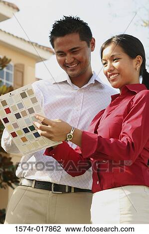 Low angle view of a young couple choosing color from a color swatch View Large Photo Image Stock Image - Low angle view of a young couple choosing color from a color swatch. Fotosearch