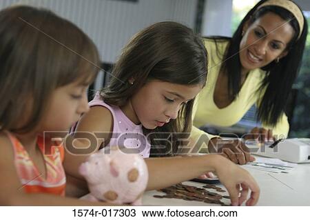 Mother looking at her two daughters counting coins View Large Photo Image Stock Image - Mother looking at her two daughters counting coins. Fotosearch