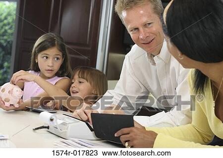 Parents looking at each other with their two daughters standing near them View Large Photo Image Stock Image - Parents looking at each other with their two daughters standing near them. Fotosearch