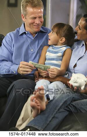 Stock Photo - Parents sitting with their daughter smiling. Fotosearch