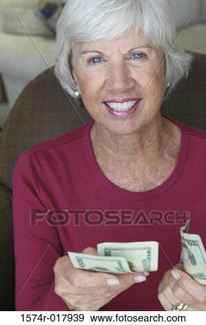 Portrait of a senior woman holding money View Large Photo Image Stock Photo - Portrait of a senior woman holding money. Fotosearch