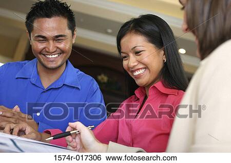 Real estate agent talking to a young couple View Large Photo Image Stock Photograph - Real estate agent talking to a young couple. Fotosearch