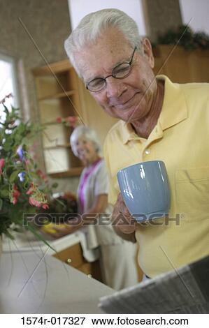 Senior man holding a coffee cup reading a newspaper View Large Photo Image Stock Photo - Senior man holding a coffee cup reading a newspaper. Fotosearch