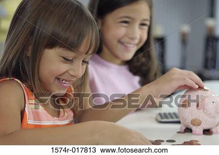 Side profile of two sisters inserting coins into a piggy bank View Large Photo Image Stock Image - Side profile of two sisters inserting coins into a piggy bank. Fotosearch