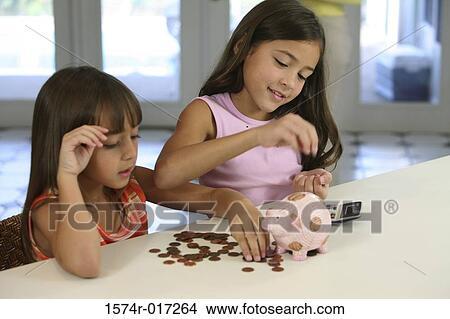 Two sisters counting coins from a piggy bank View Large Photo Image Picture - Two sisters counting coins from a piggy bank. Fotosearch