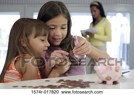 Two sisters looking at a coin with their mother standing in the background View Large Photo Image Stock Image - Two sisters looking at a coin with their mother standing in the background. Fotosearch