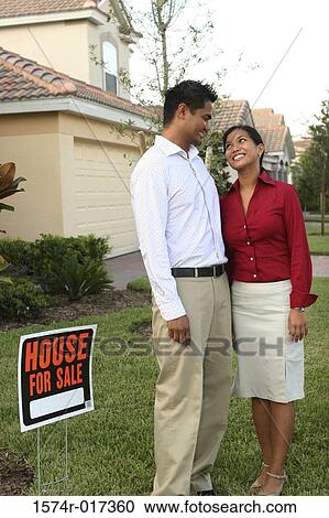 Young couple standing on the lawn of a house smiling View Large Photo Image Stock Image - Young couple standing on the lawn of a house smiling. Fotosearch