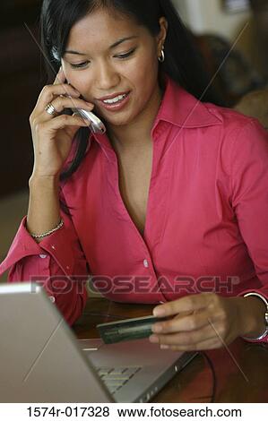 Young woman talking on a mobile phone holding a credit card View Large Photo Image Stock Photo - Young woman talking on a mobile phone holding a credit card. Fotosearch