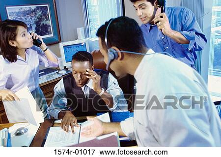 Stock Photo - Business executives on the phone in a meeting. Fotosearch