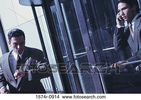 Businessman hurrying in and out of a doorway View Large Photo Image Picture - Businessman hurrying in and out of a doorway. Fotosearch